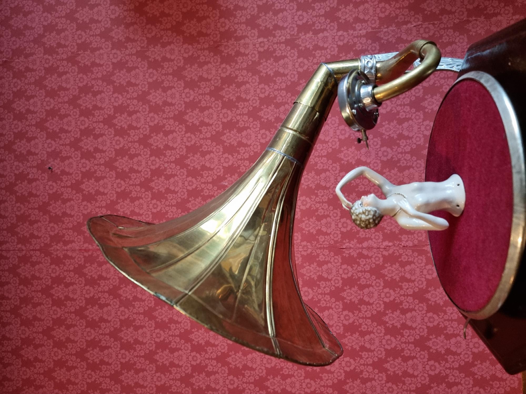 Gramophone and figurine on patterned background